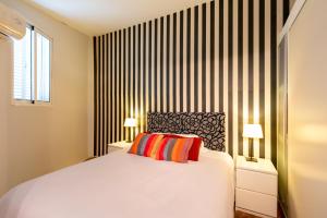 塞维利亚Plaza Nueva Terraza的一间卧室配有一张带两盏灯的大型白色床。