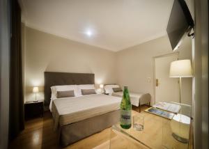 菲乌吉旅游健康及美容酒店的一间卧室配有一张床和一张桌子,上面装有一瓶