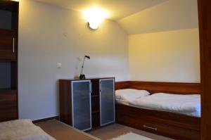 塔特兰斯卡斯特拉Apartmán G4 v Tatranskej Štrbe - Apartmánový dom Golem的卧室配有两张床,墙上有灯