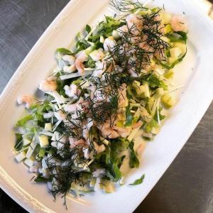 Hede松佳花园酒店的含有虾和其他蔬菜沙拉的白盘
