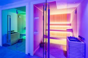 萨尔图西奥Panorama Residence Saltauserhof Resort的浴室设有粉红色灯和淋浴。