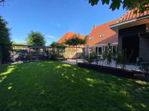 赞丹De oude slaght- luxe suite met buitensauna的一个带栅栏和房子的院子