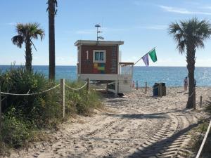 好莱坞Bwalk Resort Rentals的棕榈树海滩上的一个救生棚