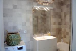 蒙彼利埃Arbre Blanc, une folie montpelliéraine的浴室配有盥洗盆、镜子和浴缸