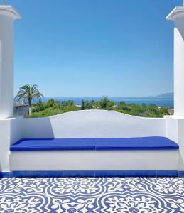 阿纳卡普里La Giuliva Charming Rooms的天井顶部的蓝色和白色床
