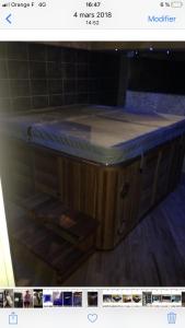克莱蒙费朗Logement haut de gamme jacuzzi sauna的木制浴缸及蓝色台面