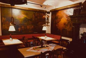 吕德斯海姆Berg´s Backpacker的餐厅设有两张桌子,墙上挂着一幅大画