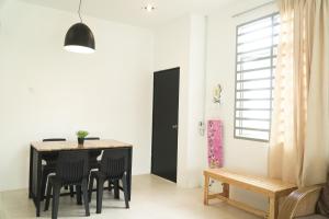 关丹Cozy, Spacious, Air Cond UMP Gambang Homestay -- The Pigeon Guest House的一间用餐室,配有黑色的桌子和椅子