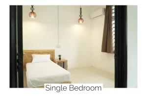 关丹Cozy, Spacious, Air Cond UMP Gambang Homestay -- The Pigeon Guest House的一间卧室配有一张床和两个吊灯