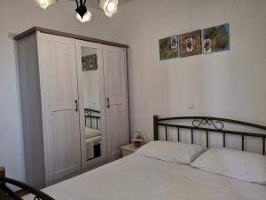 米欧纳致敬铎别墅公寓的一间卧室配有一张床、一个衣柜和一个窗户。