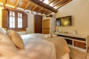 巴尔韦尔德德尔夫雷斯诺Casa Rural A Cashiña da Lagarteira的卧室配有一张白色大床和电视。