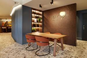 圣塞瓦斯蒂安桑塞贝酒店的配有木桌和橙色椅子的用餐室