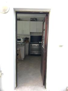赫罗德斯湾Apartment Ozone的通往厨房的开放式门,厨房配有白色橱柜