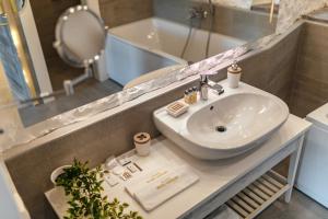 赫尔采格诺维Boutique Hotel Capitano的浴室配有盥洗盆、镜子和浴缸