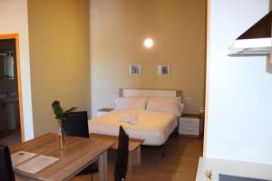 艾姆布里亚布拉瓦Apartamentos Giuliano的酒店客房配有一张床铺和一张桌子。