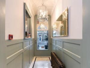 伦敦斯汤顿住宿加早餐酒店的走廊设有两面镜子和一扇窗户