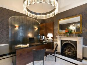 伦敦斯汤顿住宿加早餐酒店的办公室设有书桌、壁炉和吊灯
