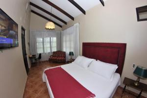 拉梅尔塞Fundo San Jose Parque Ecológico & Lodge Hotel Asociado Casa Andina的卧室配有一张白色大床和一把椅子