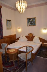 克拉根福雷西瑟城市酒店的一间卧室配有一张床、椅子和吊灯
