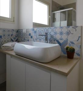 梅伦杜尼奥Casa Vacanze il Melograno的浴室内一个柜台上的白色水槽