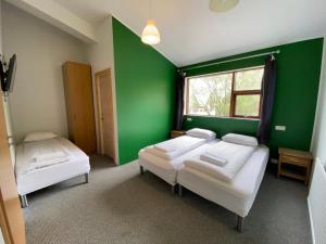 霍尔格斯兰德霍格斯兰德住宿加早餐旅馆的绿色的客房设有两张床和窗户。