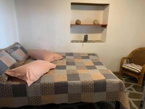 普萨克迪亚Grandmas Paradise Villa的一间卧室配有一张带 ⁇ 子毯子和椅子的床