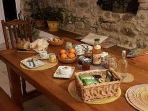 Saint-Vincent-de-BarrèsL'Attrape Rêve Insolite的一张木桌,上面有食物、饮料和篮子