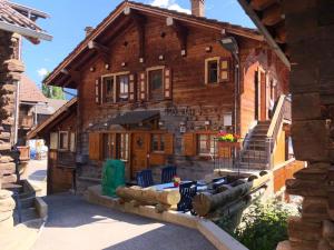 Saint-MartinAppartement "Le Ver Luisant" à Saint-Martin, Val d'Hérens, Valais的大型木屋,设有门廊和楼梯