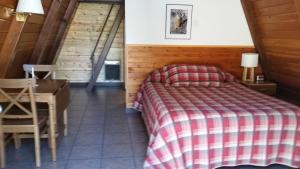 Fort KlamathAspen Inn的卧室配有一张床和一张桌子