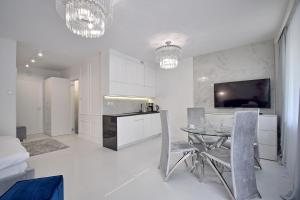 科沃布热格CRYSTAL Apartament 80m od plaży的厨房以及带桌子和电视的用餐室。