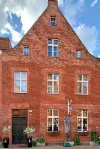 波茨坦Apartmenthaus im holländischen Viertel的红砖建筑,有黑色的门和窗户