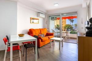 阿尔加罗沃Apartamento primera linea playa Algarrobo Costa的客厅配有橙色沙发和桌子