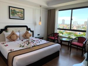 岘港Khanh Linh Hotel的一间酒店客房,床上摆放着鲜花