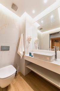 罗德镇Acandia Hotel的白色的浴室设有水槽和卫生间。