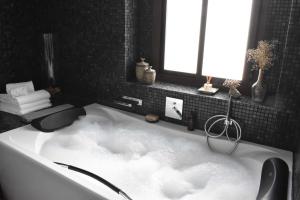 赫雷斯-德拉弗龙特拉Home Apartments Jerez的浴室配有云团浴缸。