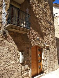 奥尔塔-德圣胡安Casa del Pintor的石头建筑,设有木门和阳台