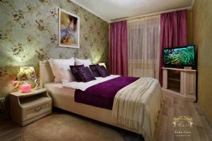 格罗德诺LIRA EuApartments的一间卧室配有一张床和一台电视。