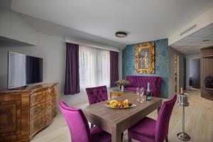 凯希道库什塔尼Kehida Termál Resort & Spa的一间带桌子和紫色椅子的用餐室