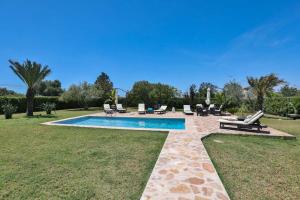 马略卡岛帕尔马Villa Kentia, charming and stylish country house close to Palma, sleep 8的庭院内带躺椅和椅子的游泳池