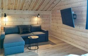 韦姆达伦Amazing Home In Vemdalen With Wifi的客厅配有蓝色的沙发和桌子
