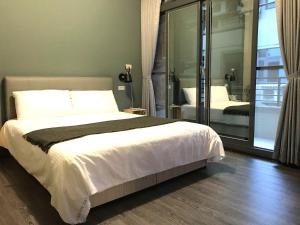中坜高铁背包客的一间卧室设有一张大床和一个滑动玻璃门