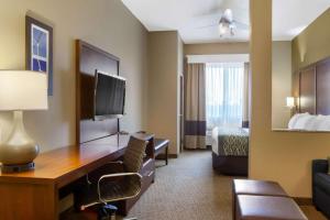 阿马里洛Comfort Inn & Suites的酒店客房配有书桌和床。