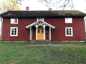 HillerstorpVandrarhem Lövö的红色和白色的房子,有黄色的门
