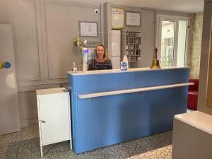 巴黎拉米拉尔酒店的站在商店里蓝色柜台后面的女人