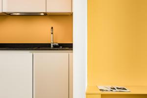 卡尔达罗Apartments Seewinkel的厨房配有白色橱柜和水槽