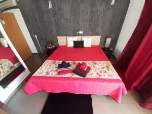 莫托拉Paraíso D`el Rio的一间卧室配有红色的床和粉色毯子
