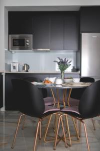 塞维利亚Arco Macarena Suite的厨房配有黑色橱柜和桌椅