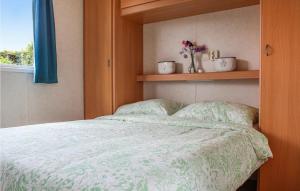 WoubruggeHuis Nr, 1的一间卧室配有一张带绿色棉被的床和窗户。