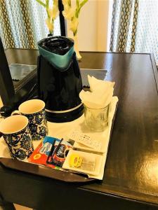 伊斯兰堡Atlas hotel的一张桌子,上面有咖啡壶和两个杯子