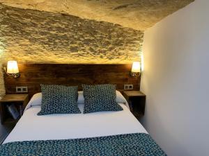 塞特尼尔Casa Cueva El Puente的一间卧室配有一张带蓝色和白色枕头的床